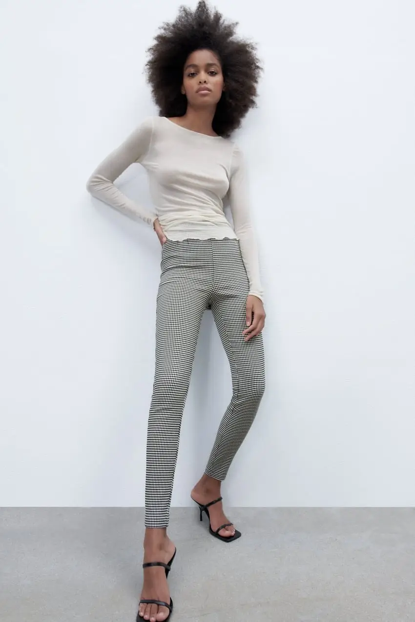 leggings de mujer con estampado de cuadros en blanco y negro. Tiro alto y calce ajustado. Detalles de diseño: cierre en el lateral.