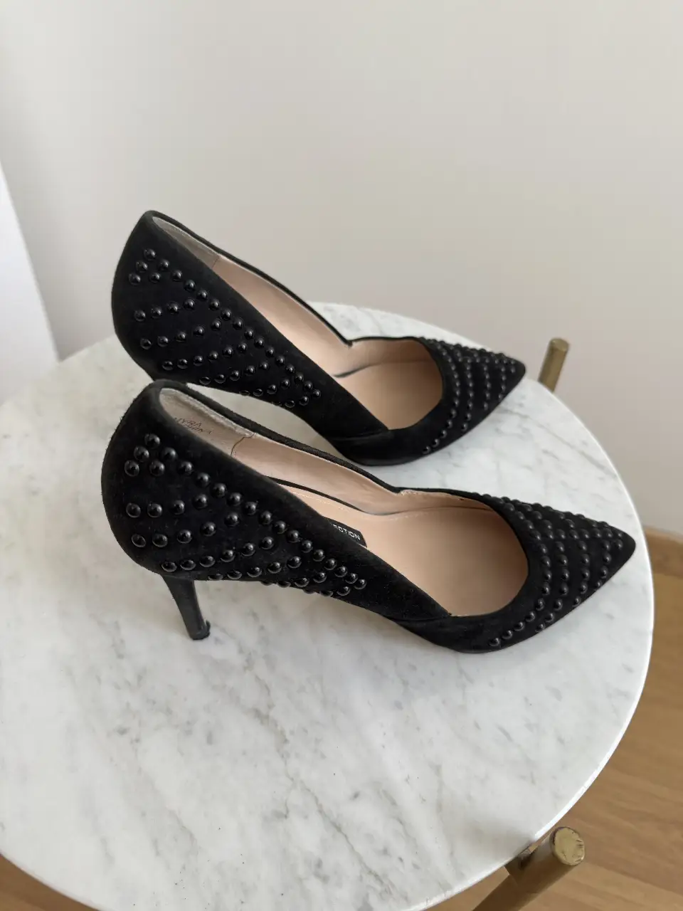 Elegantes zapatos de tacón alto negros con detalles de tachuelas. Ideales para eventos formales o para darle un toque sofisticado a cualquier outfit.