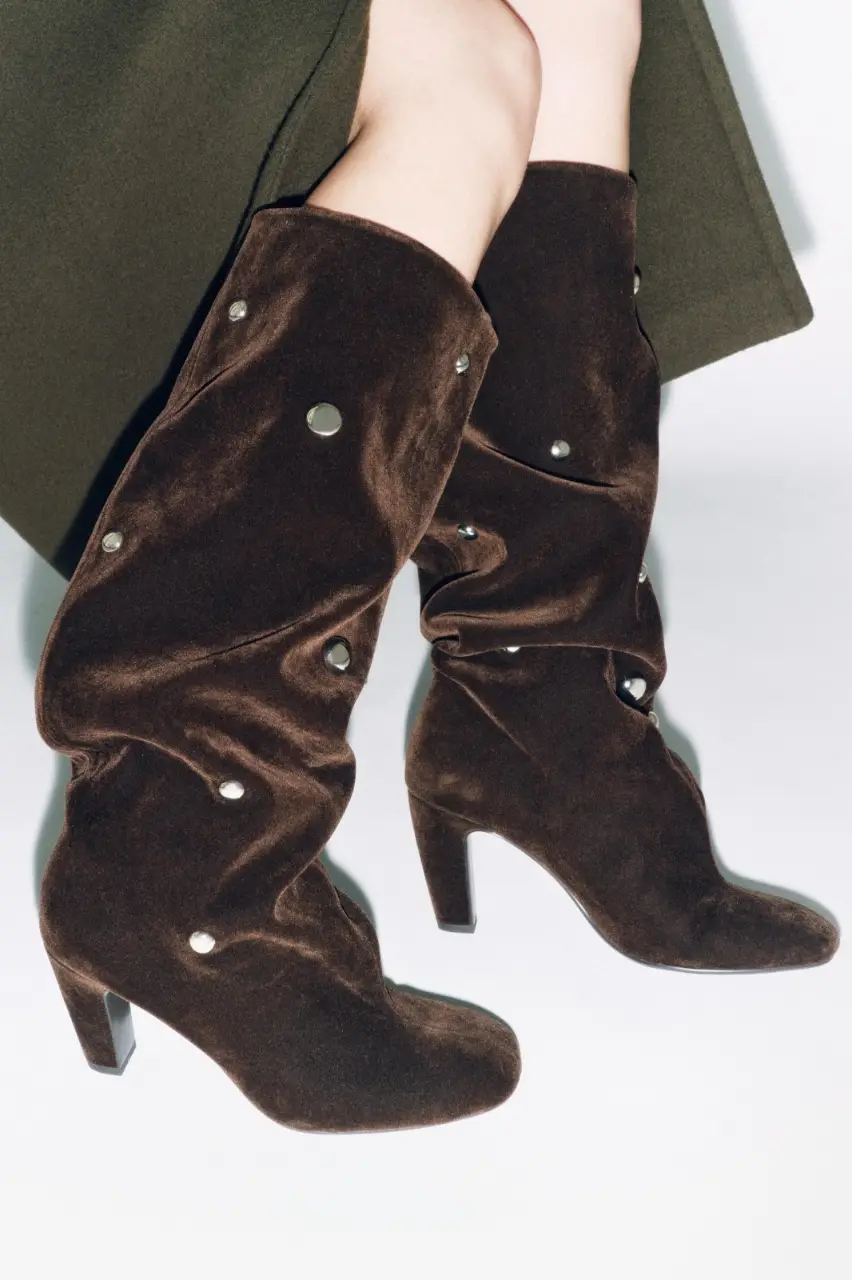 Botas de caña alta de terciopelo marrón con detalles de tachas plateadas. Diseño elegante y sofisticado, ideales para un look de fiesta o salida.