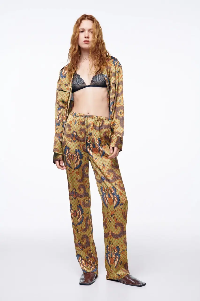 Pantalón suelto de seda con estampado floral en tonos verdes, azules y marrones. Ideal para un look cómodo y con estilo.