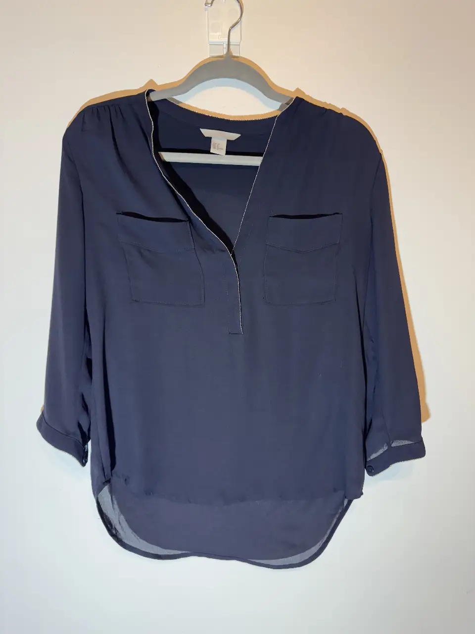 Blusa de mujer azul marino con mangas 3/4. Diseño elegante con dos bolsillos delanteros y cuello en V. Ideal para un look casual o de trabajo. talle 38