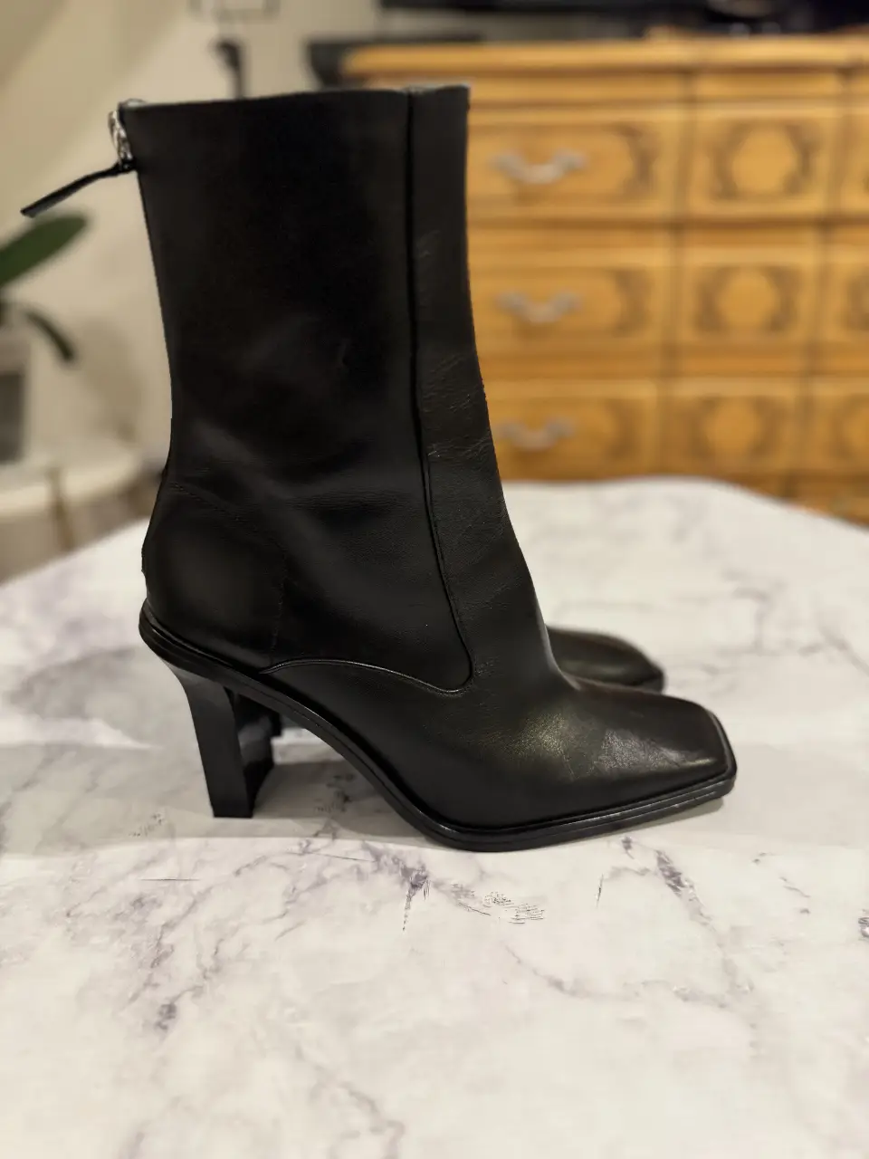 Botines negros de cuero con taco geométrico. Diseño moderno y elegante, ideales para complementar cualquier look.