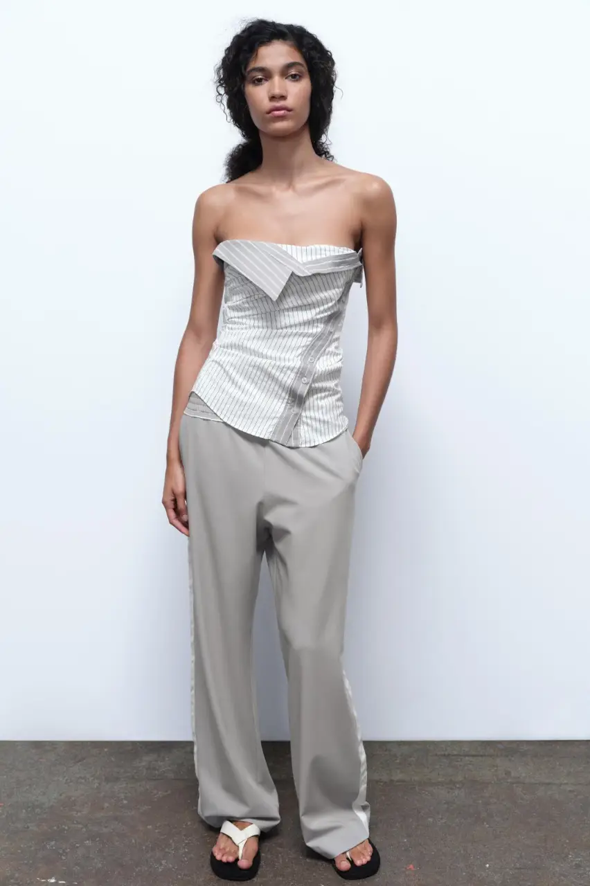 Pantalón sastrero de tiro medio con cintura elástica ajustable con cordones interiores. Bolsillos laterales y falsos bolsillos de vivo en espalda. Pierna recta con detalle de banda lateral combinada a contraste.