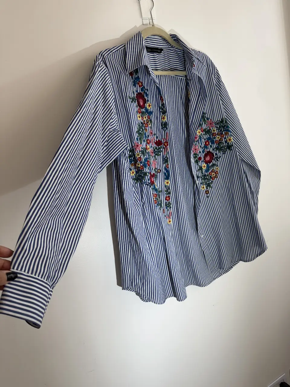 Camisa a rayas azul y blanca con bordado floral en el frente. Ideal para un look casual y fresco. Es talle S pero es super amplia va perfecto para M