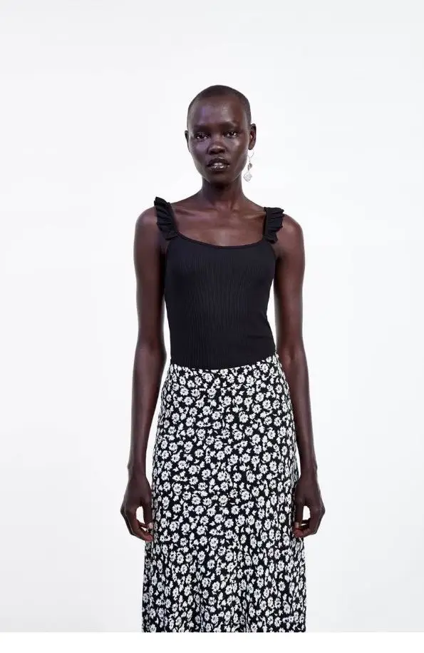 Body negro con breteles finos y volados en los hombros. Ideal para combinar con polleras o pantalones de cintura alta.