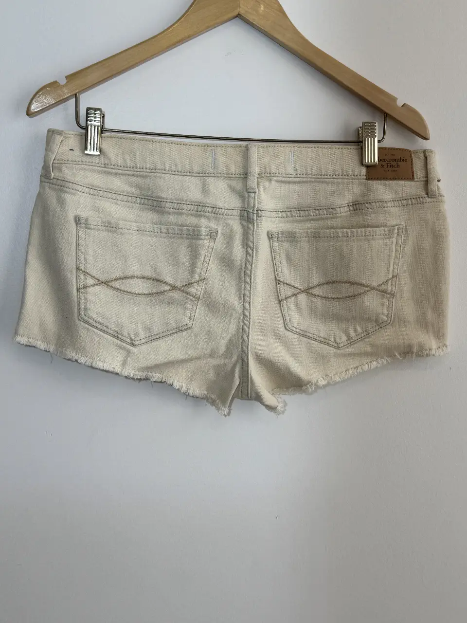Short de jean color crudo de la marca Abercrombie & Fitch. Corte clásico con detalles de costura en contraste y bordes deshilachados. Ideal para un look casual y fresco.