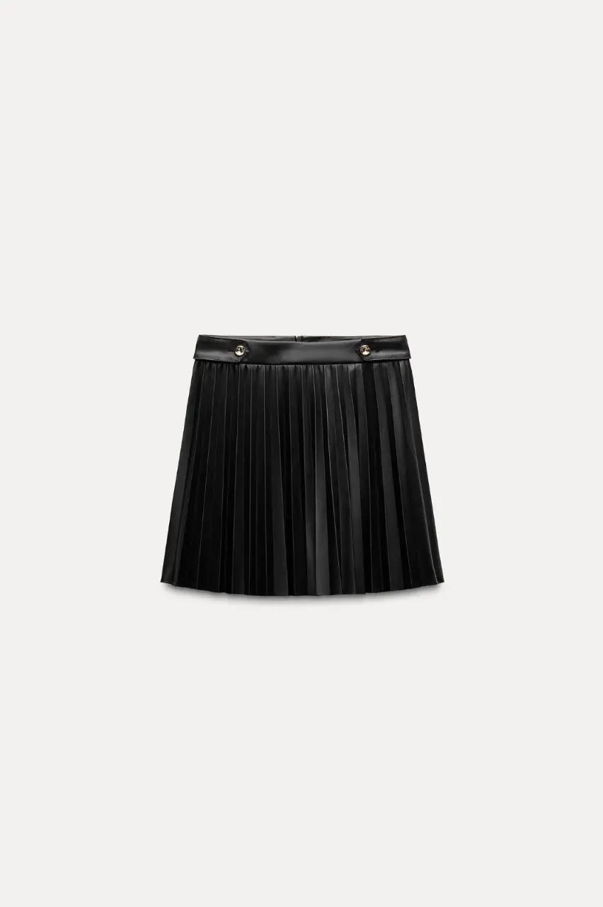 Pollera tableada de cuero sintético negro, con detalles de botones dorados. Ideal para un look elegante y moderno. art 364