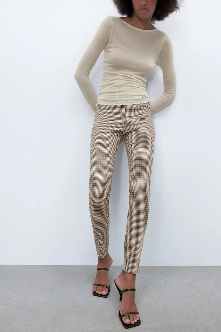 Leggings de mujer con estampado a cuadros en tonos marrones y blancos. Diseño ajustado, con cierre lateral y tiro medio. Ideal para un look elegante y moderno.