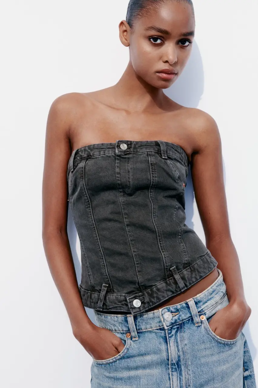 Top strapless de jean negro, con cierre metálico en la espalda y detalles de costuras. Ideal para un look casual y moderno.