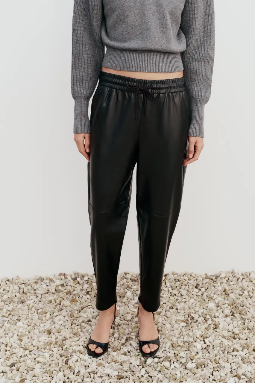 Pantalón de tiro alto con cintura elástica ajustable con cordones. Bolsillos delanteros. Bajo acabado en puño elástico. Ideal para un look casual y moderno.