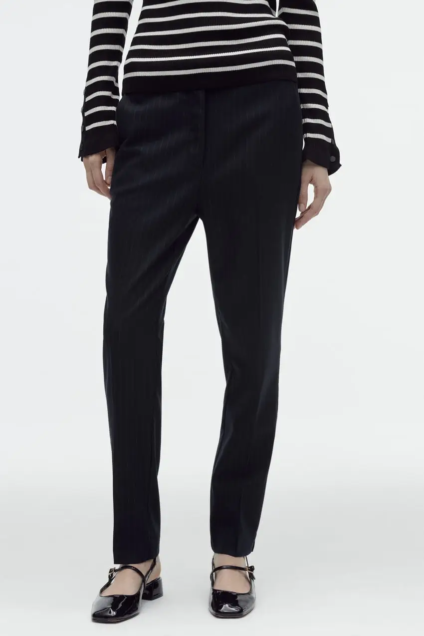 Pantalón sastrero negro con pinzas y corte recto. Ideal para un look formal o de oficina. Confeccionado en tela de calidad, ofrece un ajuste cómodo y elegante. Perfecto para combinar con blusas, camisas o sweaters.