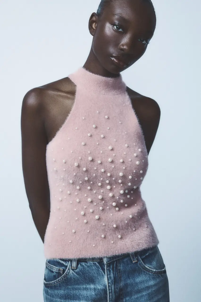 Top halter de tejido suave en color rosa, adornado con perlas a contraste. Ideal para un look elegante y moderno.