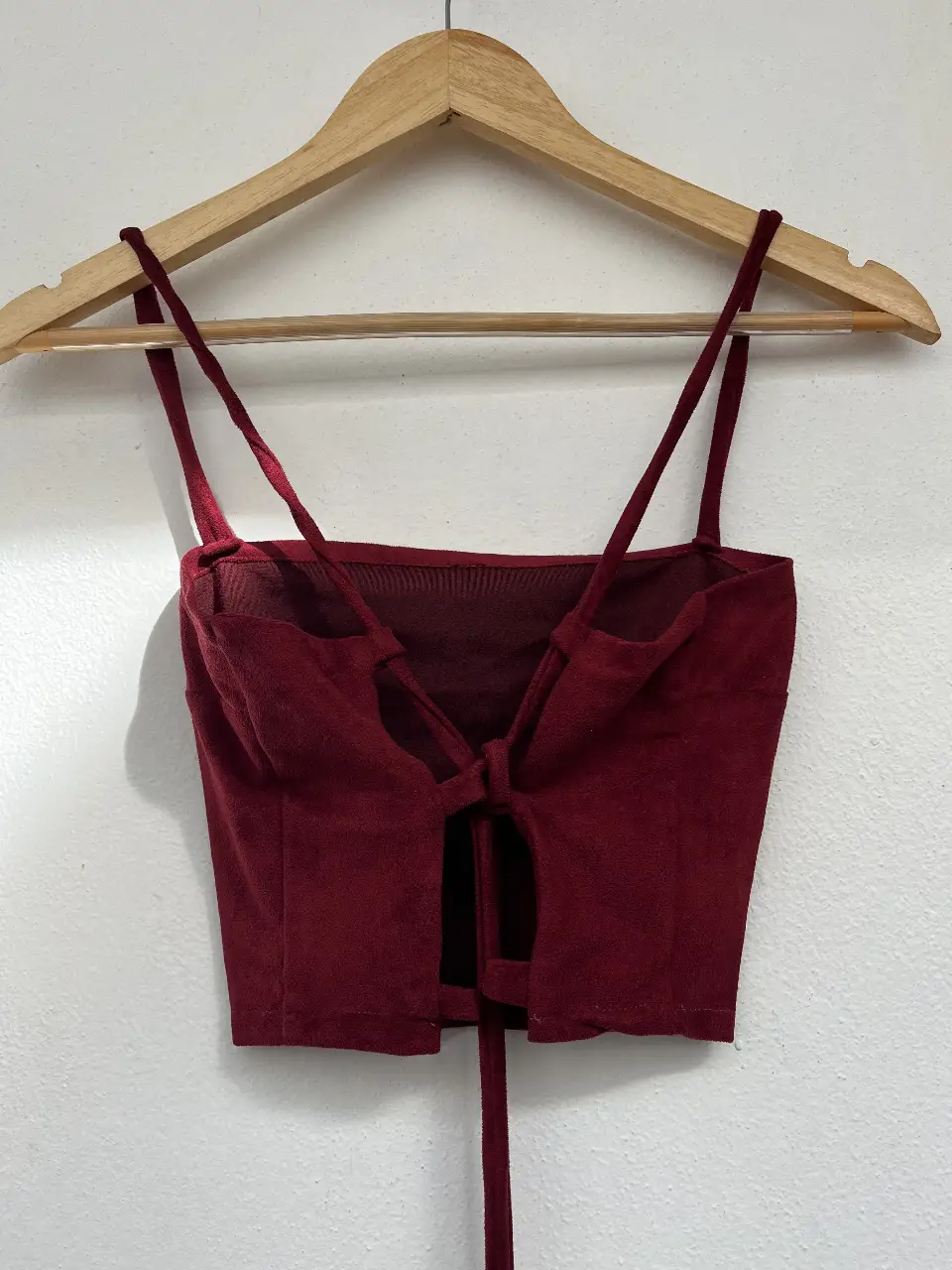 Top de mujer color bordó, con tiras finas y detalle de lazo en la espalda. Ideal para un look moderno y sensual.
