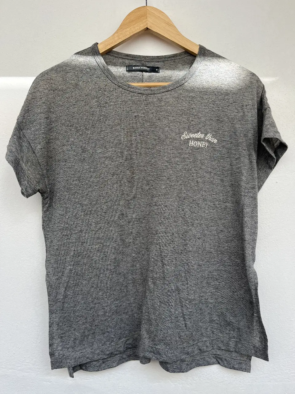 Remera gris de mujer, con estampado "Sweeter than honey" en blanco. De corte clásico, ideal para un look casual y cómodo.