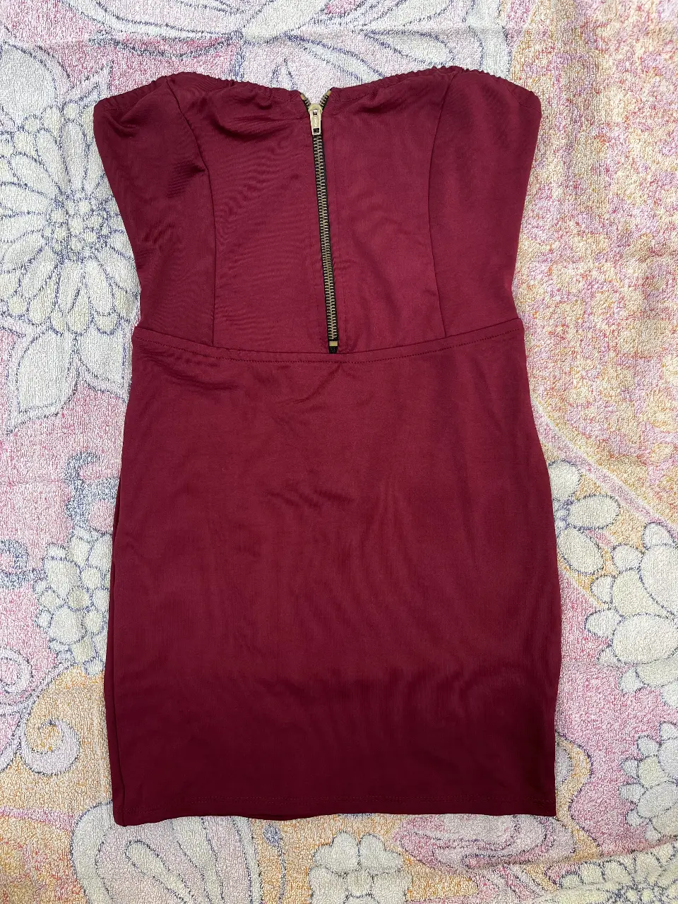 Vestido mini strapless de color bordó, con cierre frontal y detalles en la espalda. Ideal para fiestas y eventos.