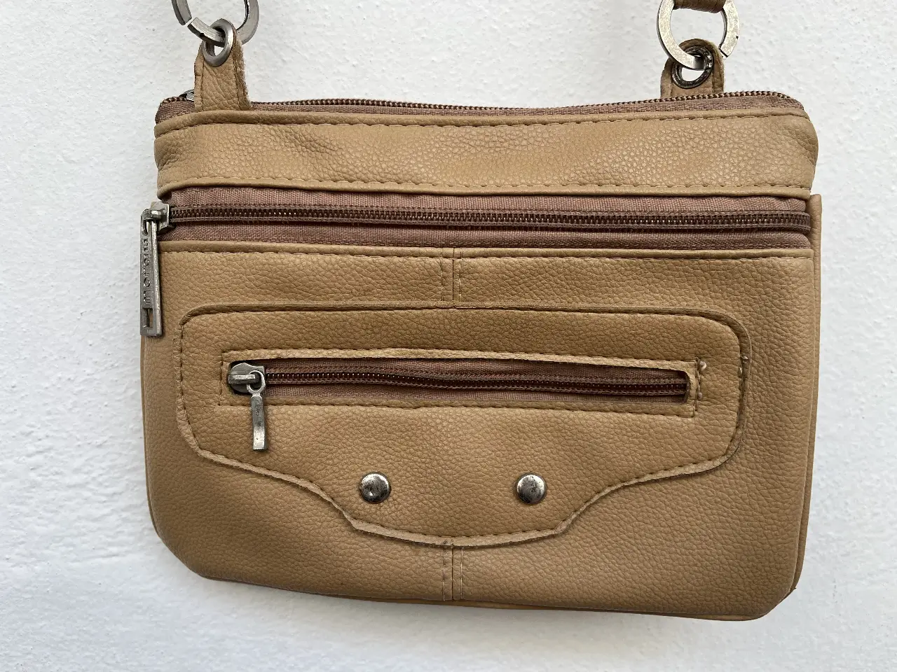 Bandolera /cartera de cuero sintético color marrón claro, con múltiples compartimentos con cierres. 