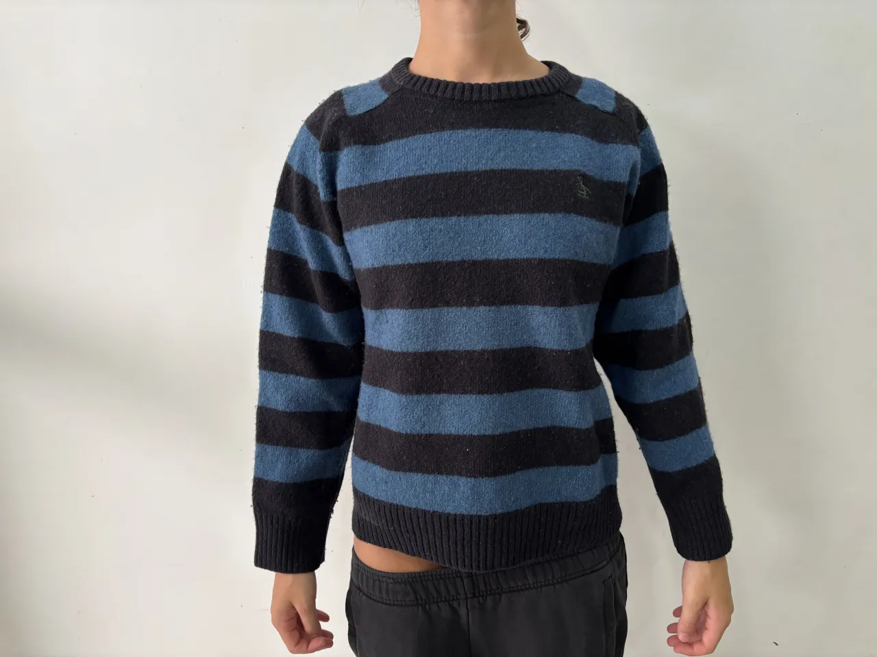 Sweater de lana a rayas azules y negras, ideal para un look casual y cómodo. Perfecto para los días frescos de otoño o invierno.