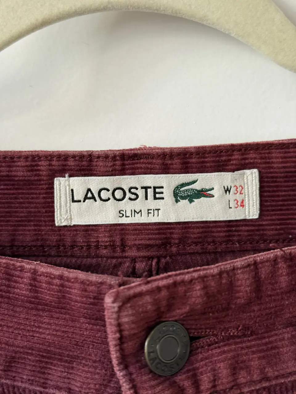 Pantalón de hombre de corderoy color bordó, corte slim fit de la marca Lacoste. Talle W32 L34. Ideal para un look casual y cómodo.