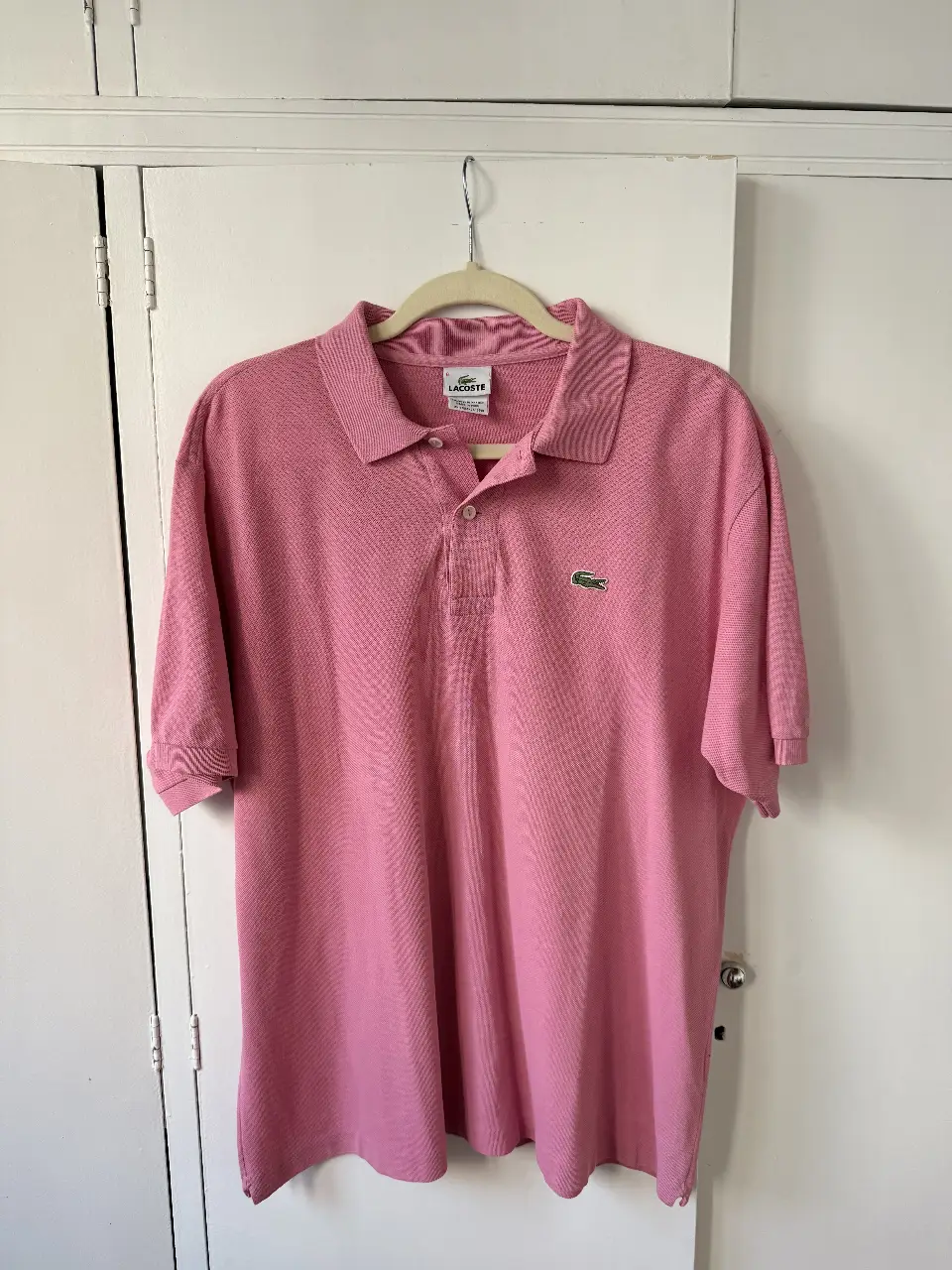 Chomba polo Lacoste rosa, talle 6, diseño clásico con el logo del cocodrilo bordado. Ideal para un look casual.