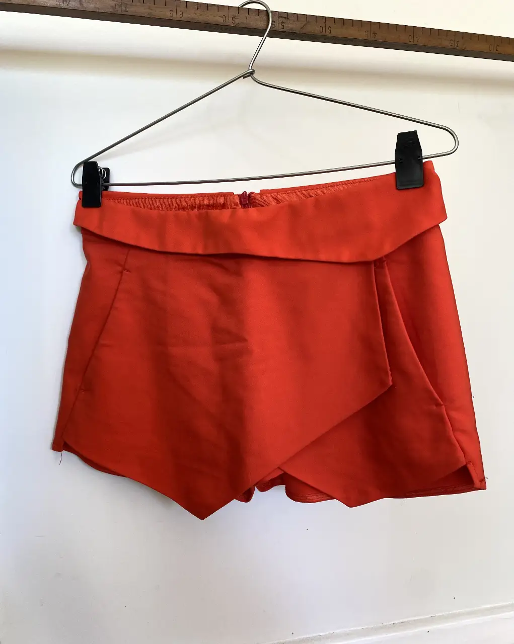 Short/pollera asimétrico color rojo. Detalle de solapa cruzada en el frente y cintura rebatida hacia abajo. Talle XS. Marca: Zara.