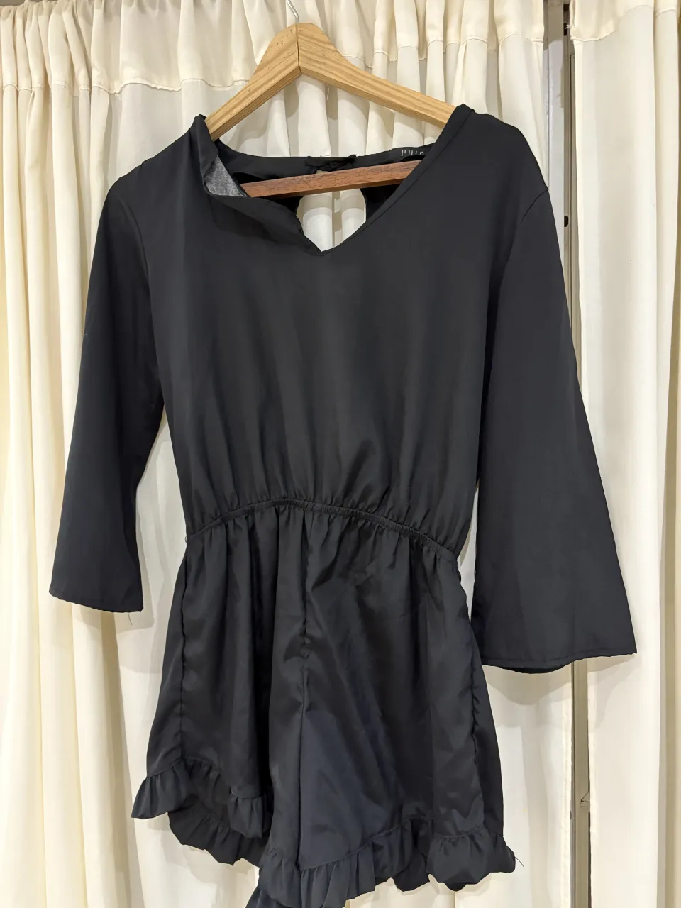 Mono negro con mangas acampanadas y volados en el borde inferior. Elástico en la cintura para un ajuste cómodo. Ideal para una salida o fiesta.