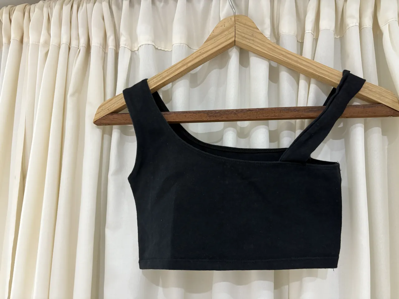 Top negro de breteles finos, escote cuadrado y corte al cuerpo. Ideal para un look casual o deportivo.