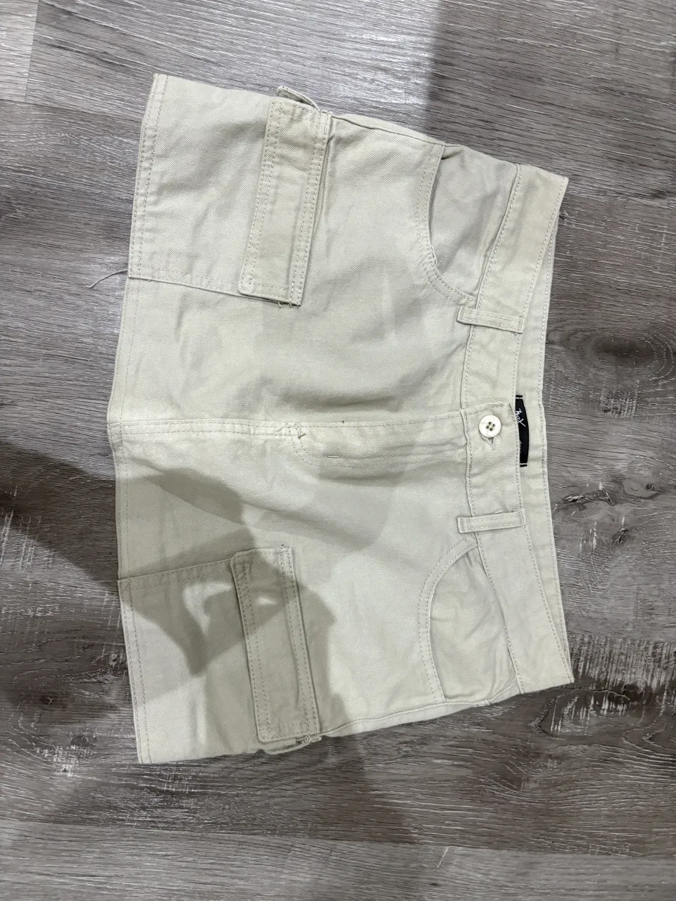 pollera cargo de jean color crudo. Tiro alto con cierre y botón. Tiene bolsillos cargo a los costados y bolsillos tipo chino en la parte delantera y trasera. Un básico súper canchero para armar looks de día o de noche.