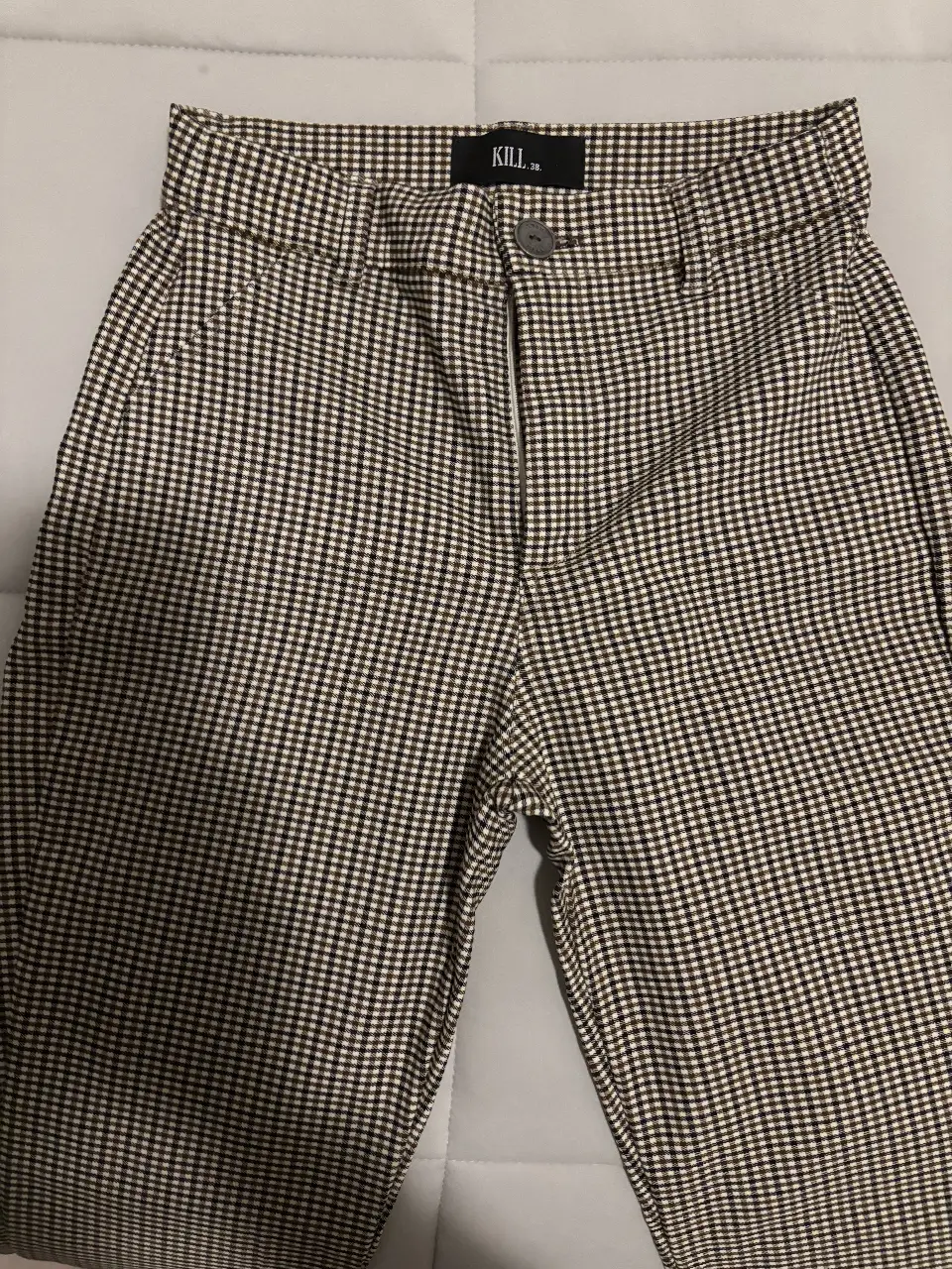 Pantalón sastrero a cuadros en tonos marrones y blancos. Tiro medio, con cierre y botón. Ideal para un look casual o de trabajo. Talle S (38)