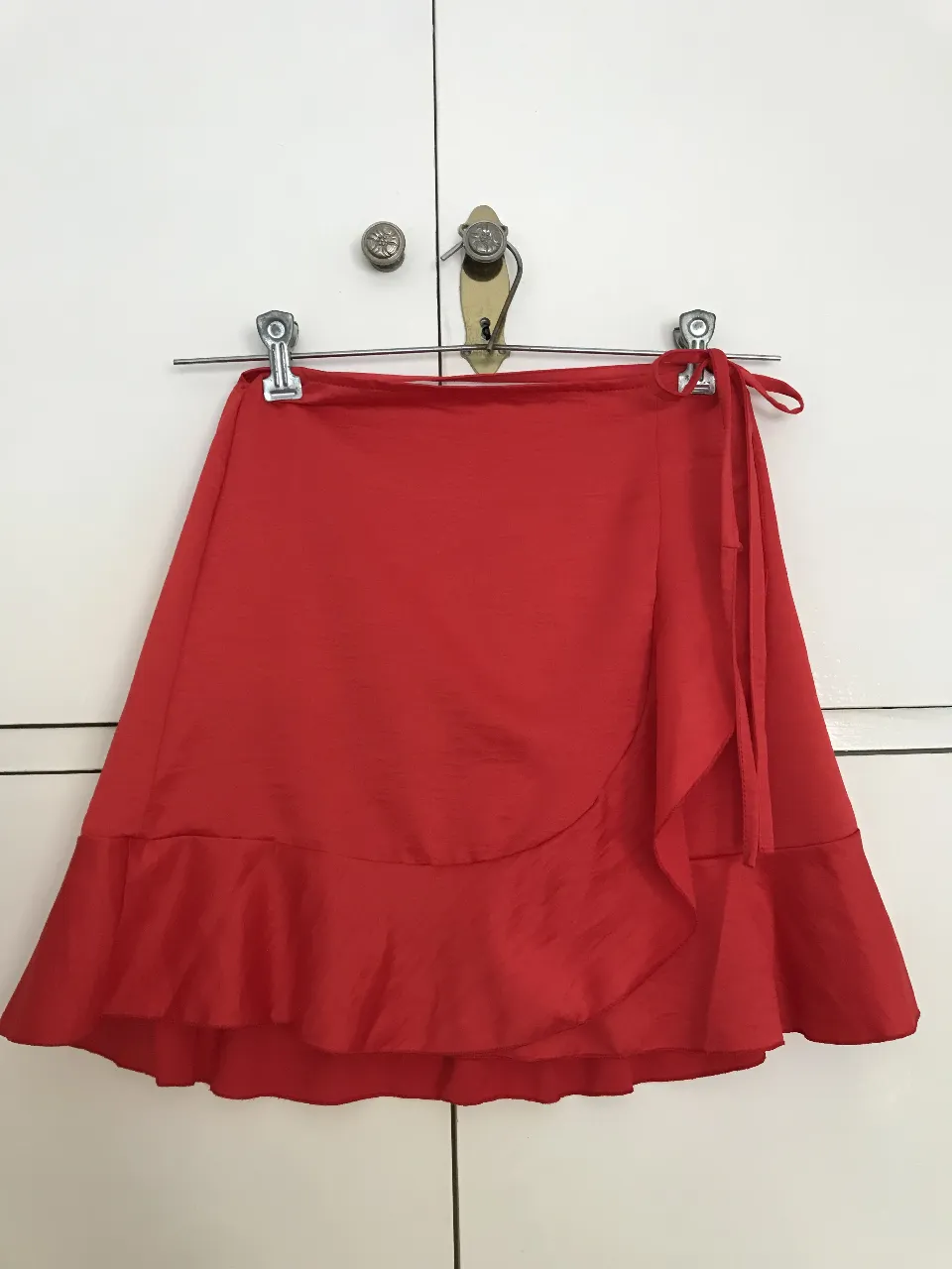 Pollera larga de mujer, estilo wrap, color rojo. Ideal para un look elegante y moderno. Confeccionada en tela suave y fluida, con detalle de volados en el borde.