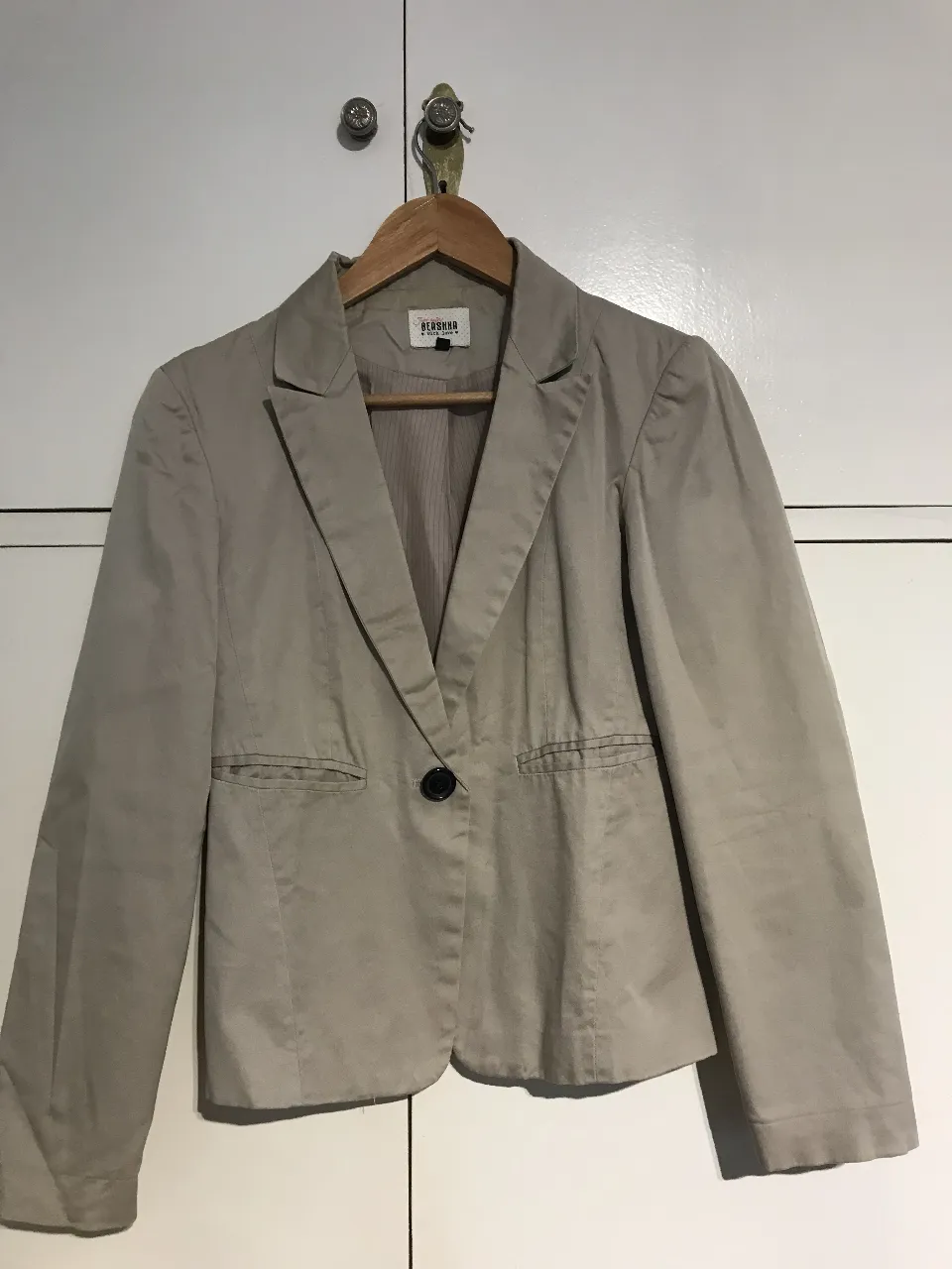 Blazer Bershka color crudo, con un botón y bolsillos delanteros. Ideal para un look elegante y versátil.