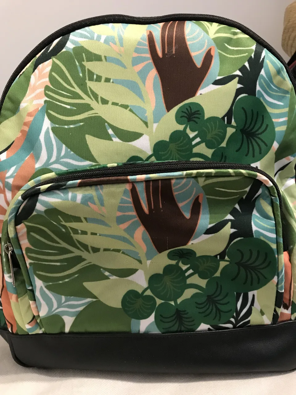 Mochila con estampado de tropical, ideal para llevar tus cosas con estilo. Cuenta con un bolsillo frontal y correas ajustables. 37x30x11