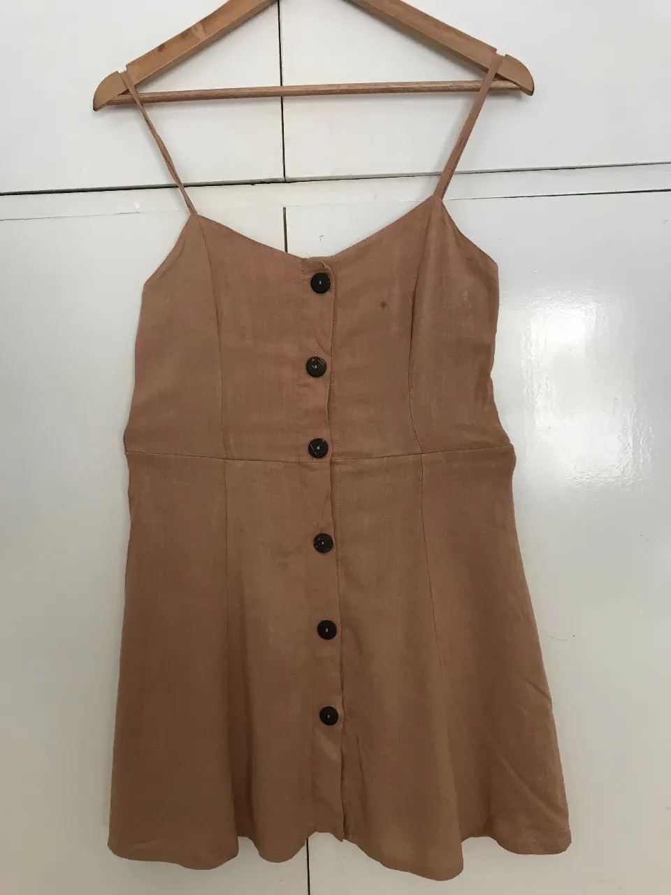 Vestido mini  color marrón con botones delanteros y tirantes finos. Ideal para un look casual y fresco.