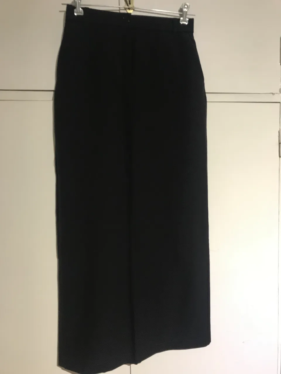 Falda  sastrera negro, ideal para un look formal o de trabajo. Corte recto y clásico, perfecto para combinar con camisas o blazers.