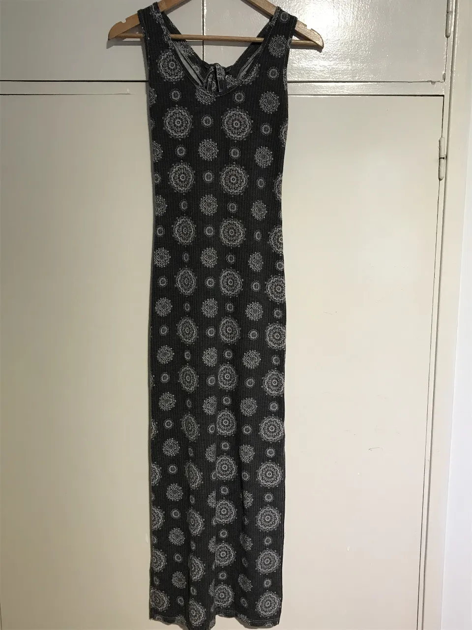 Vestido largo de mujer, con estampado de flores en color gris. Diseño con espalda descubierta y lazo. Ideal para un look casual y fresco.