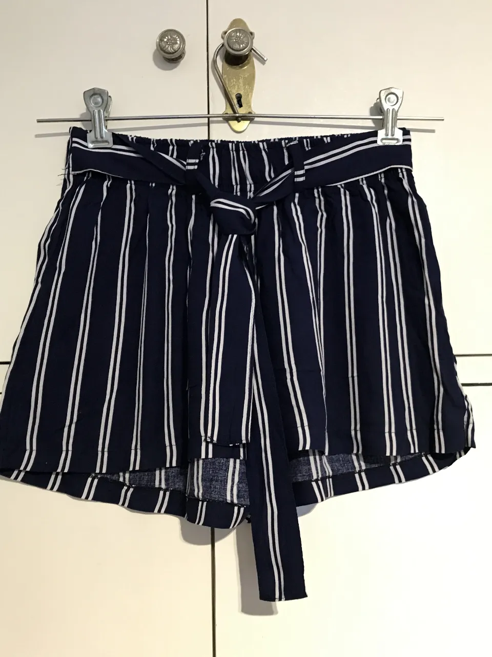 Short de mujer a rayas verticales en azul marino y blanco, con cintura alta y lazo para atar. Ideal para un look casual y fresco.