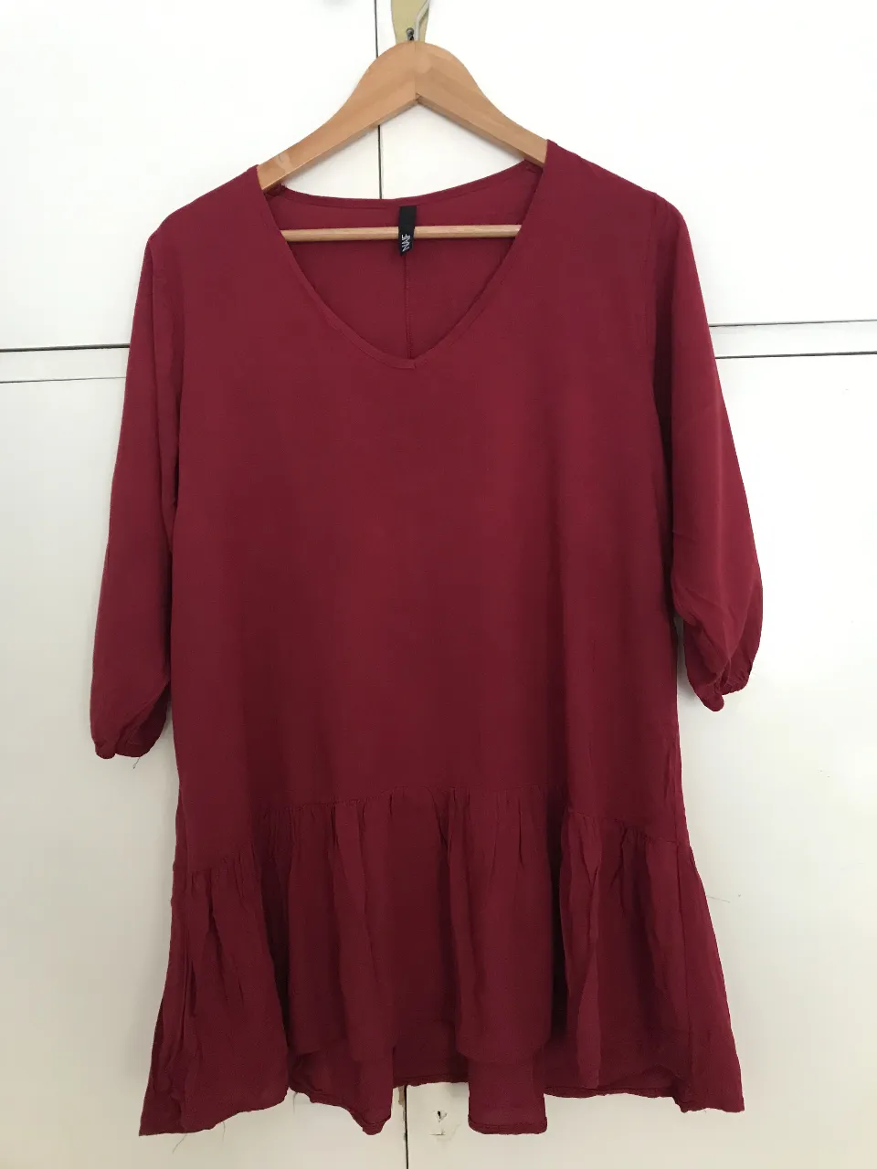 Vestido de mujer color rojo oscuro con mangas 3/4 con elástico y detalle de volados en la parte inferior. Ideal para un look casual y cómodo.