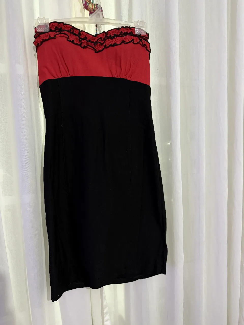 Vestido strapless de fiesta, con corpiño rojo y detalles de volados, y falda negra. Ideal para eventos especiales.