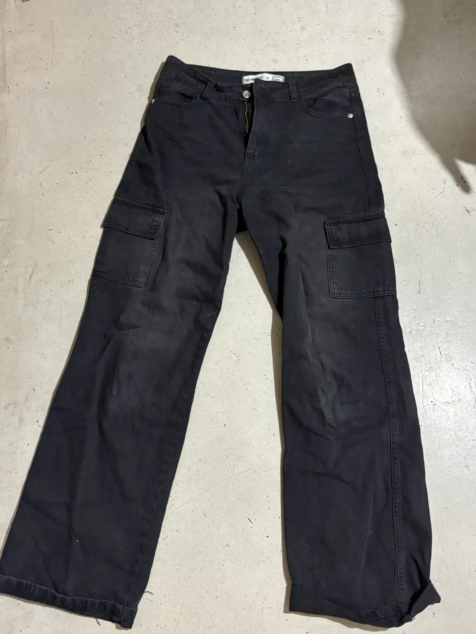 Pantalón cargo tiro alto, color negro, con bolsillos laterales y corte ancho. Ideal para un look urbano y canchero.