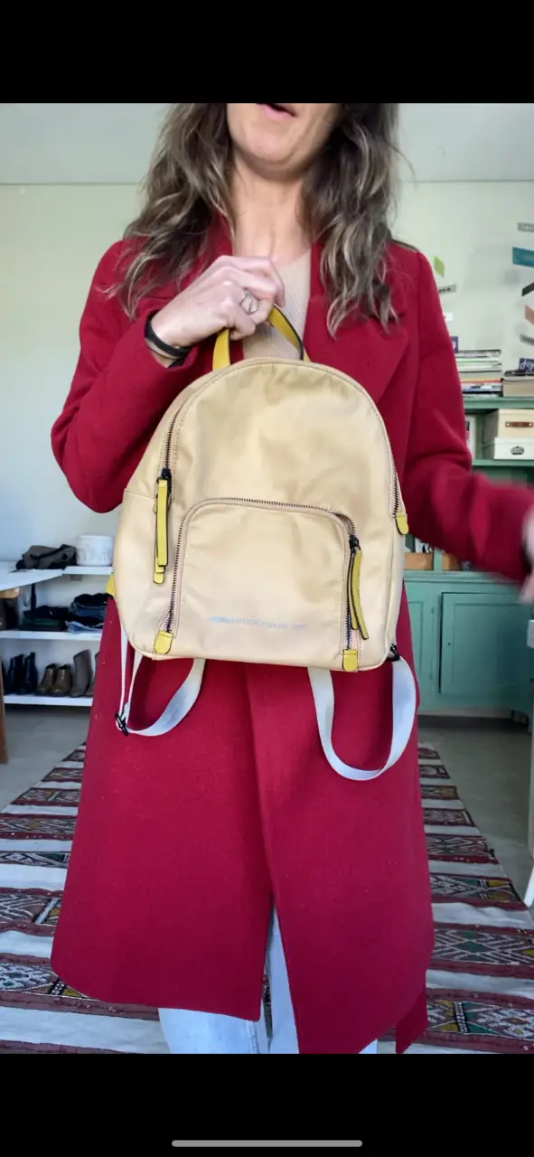 Mochila de color beige con detalles en amarillo y gris. Ideal para llevar tus cosas con estilo y comodidad. Perfecta para el día a día.