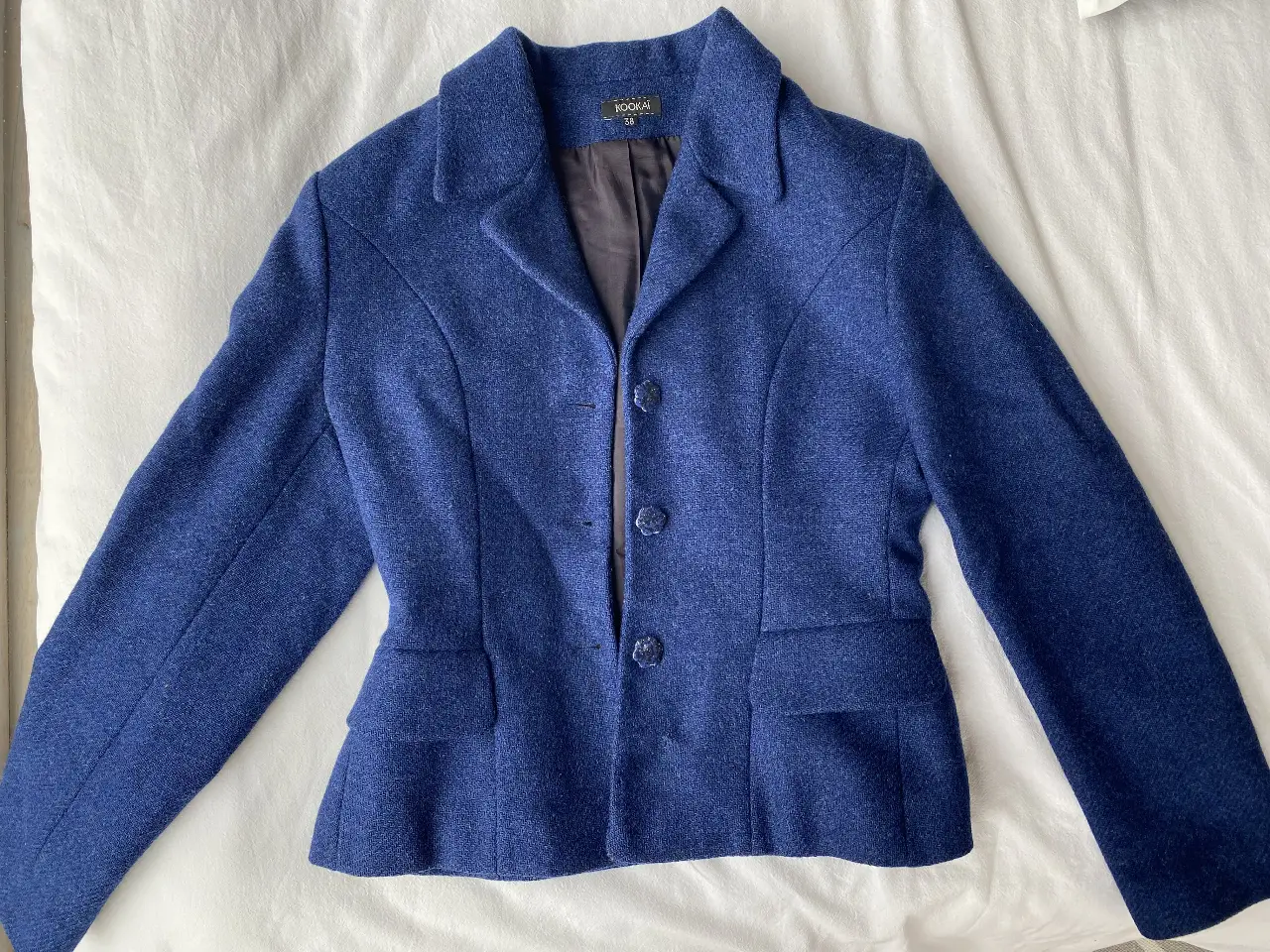 Elegante blazer azul de la marca Kookai, ideal para un look sofisticado. Confeccionado en un tejido de calidad, este blazer entallado presenta un diseño clásico con botones y bolsillos funcionales. Tiene un pequeño detalle de costura que se ve en la última foto.