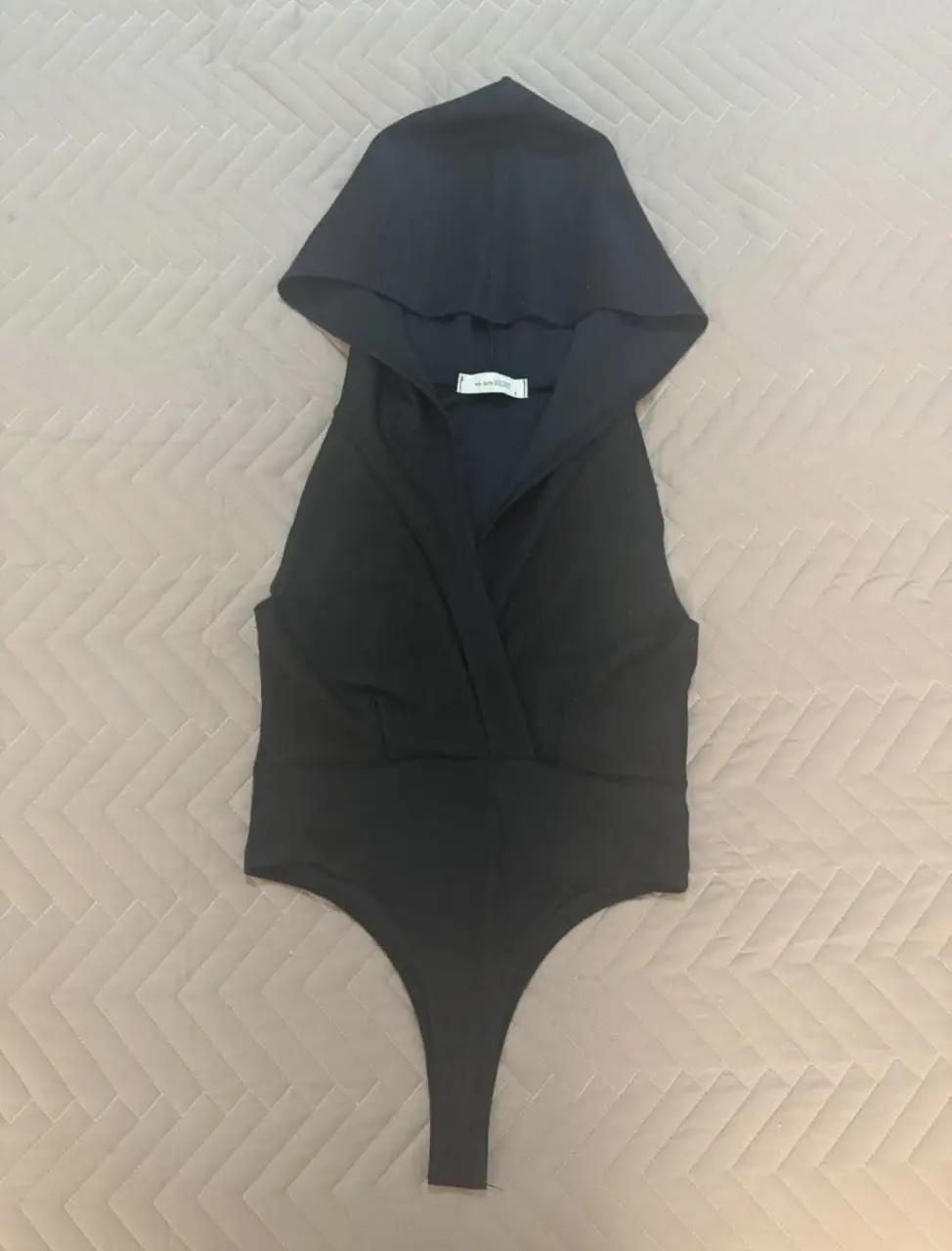 Body negro con capucha, ideal para un look moderno y audaz. Perfecto para combinar con jeans o faldas. Diseño elegante y versátil. la tela es negra con brillos. sede hasta un talle M
