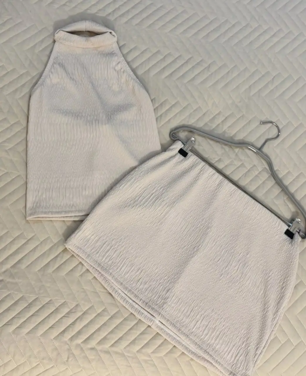 Conjunto de top halter y pollera mini en color crudo, ideal para un look fresco y moderno. El top presenta un diseño halter que realza los hombros, mientras que la pollera mini completa el conjunto con un estilo juvenil y versátil. Perfecto para crear outfits casuales con un toque chic. Marca: Audaz