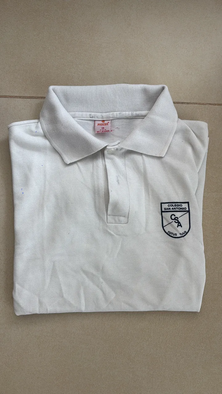 Remera blanca tipo polo, ideal para el colegio o uso diario. Con escudo bordado del "Colegio San Antonio" en el pecho.