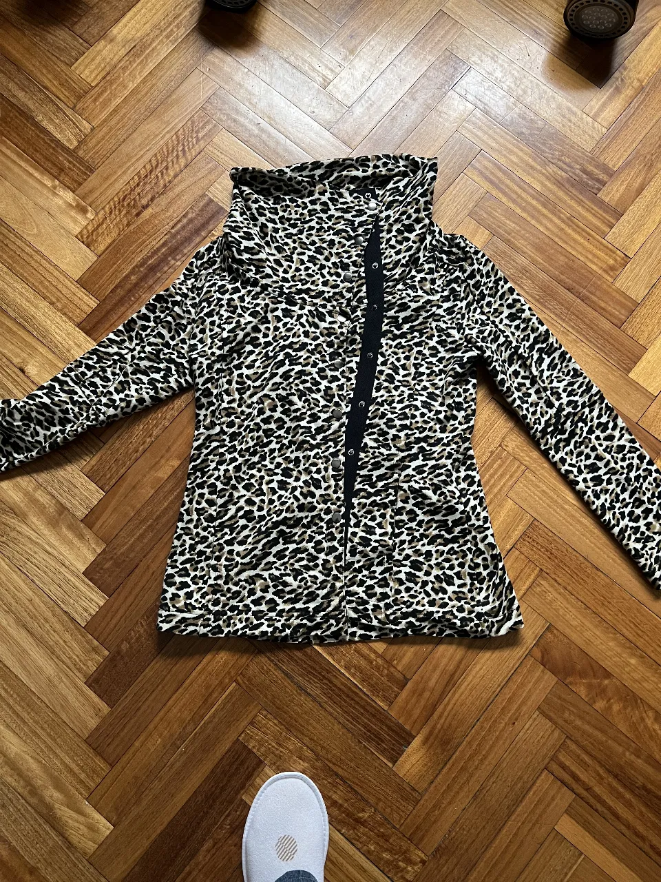 Blusa con estampado de leopardo, cuello alto y cierre frontal con botones. Ideal para un look audaz y moderno.
