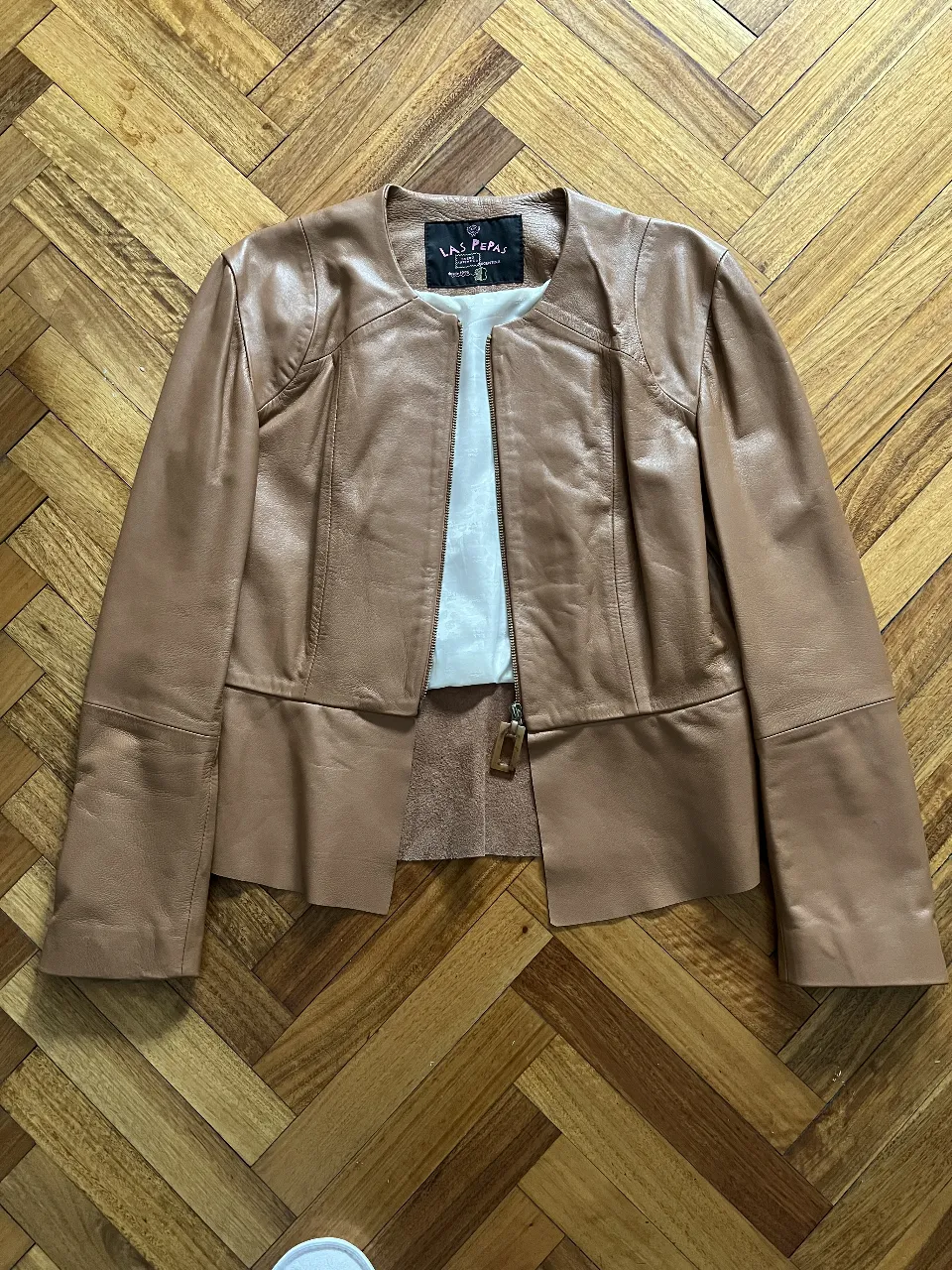 Campera de cuero marrón de la marca Las Pepas, con cierre y corte entallado. Ideal para un look elegante y moderno.