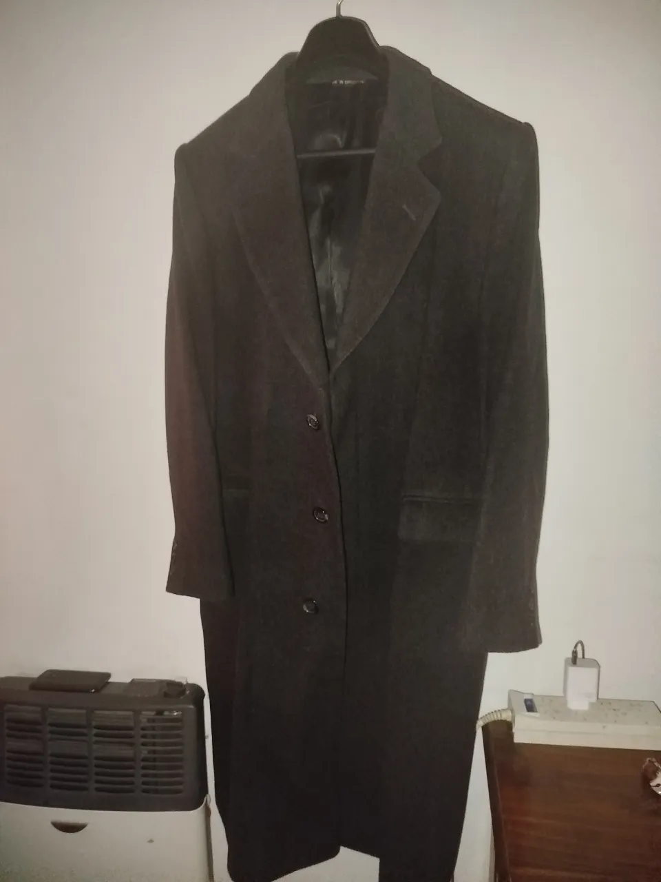  Sobretodo largo de 100 % lana virgen , color gris oscuro. Posee cuello solapa, tres botones al frente y bolsillos laterales.