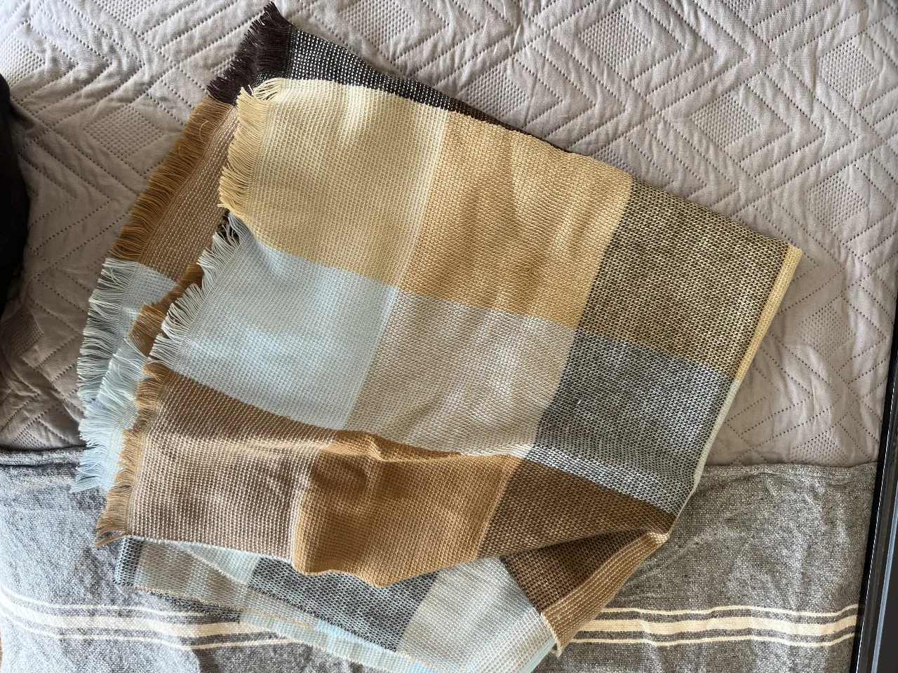 Manta a cuadros en tonos marrones, beige y celeste. Ideal para usar en el sillón o en la cama. Con flecos en los bordes.