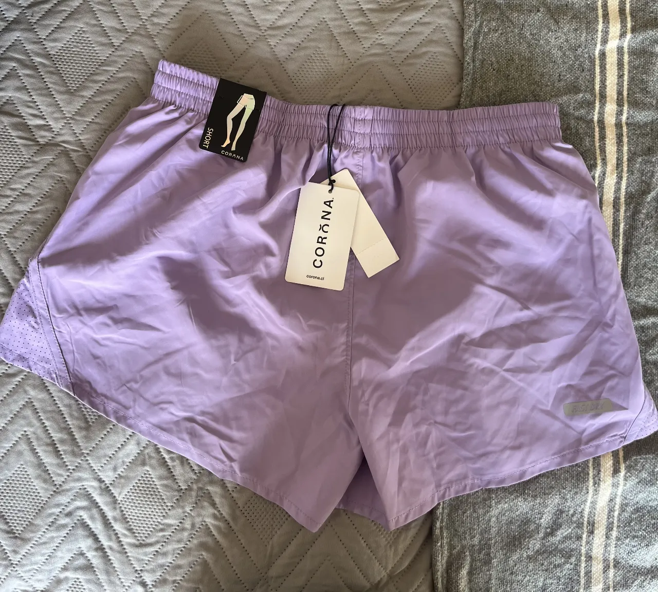 Short deportivo de mujer, color lila. Confeccionado con tela liviana y respirable, ideal para actividades físicas. Cuenta con cintura elastizada y detalles de diseño.