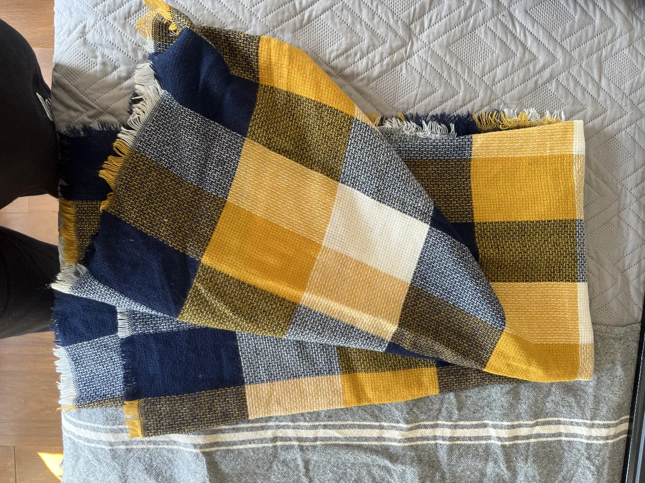 Bufanda de lana a cuadros en tonos amarillo y azul marino, ideal para abrigarte con estilo en invierno. Diseño clásico y versátil.