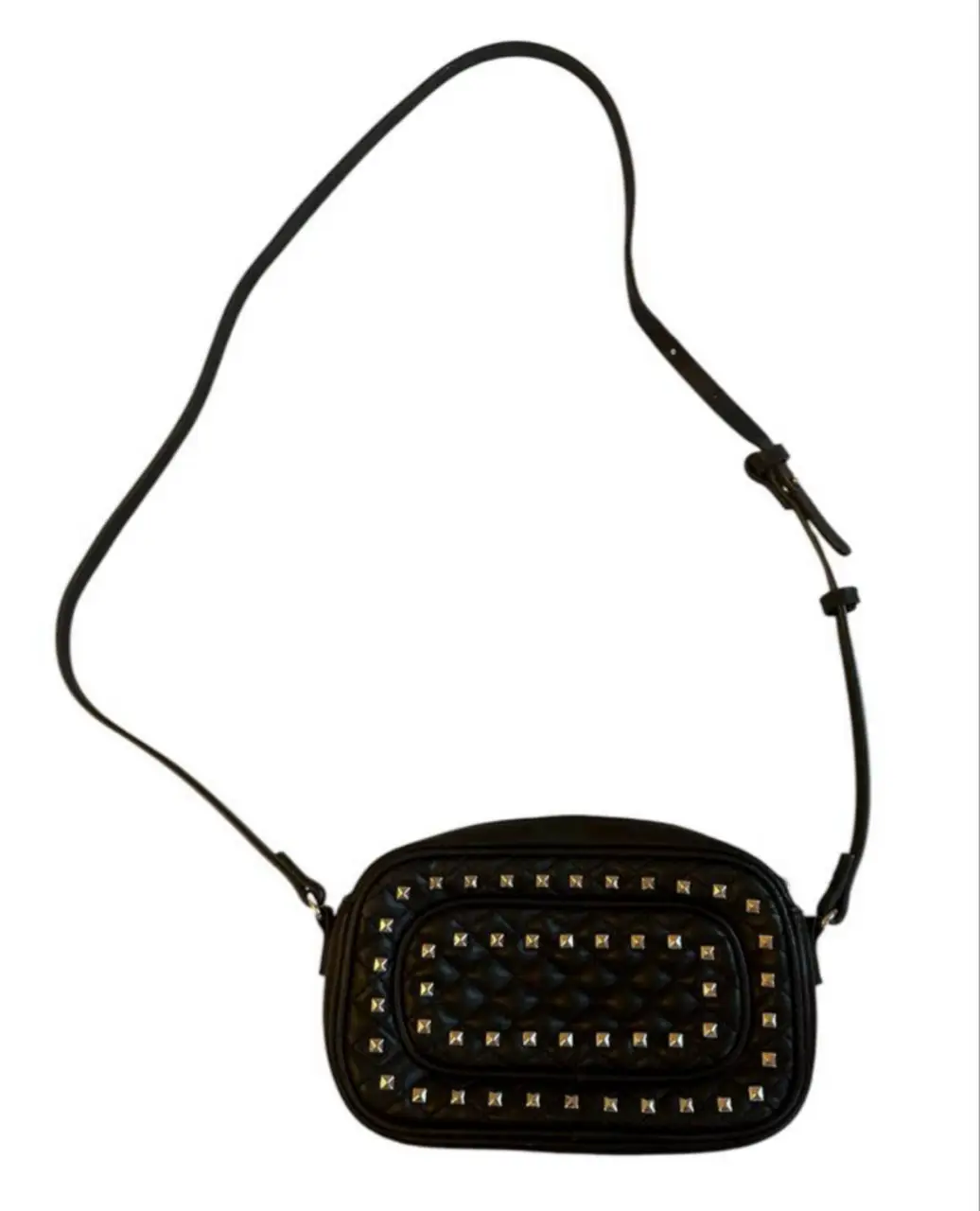 Bandolera negra con tachas plateadas, ideal para un look moderno y canchero. De Zara, un uso, está impecable por afuera y por dentro!